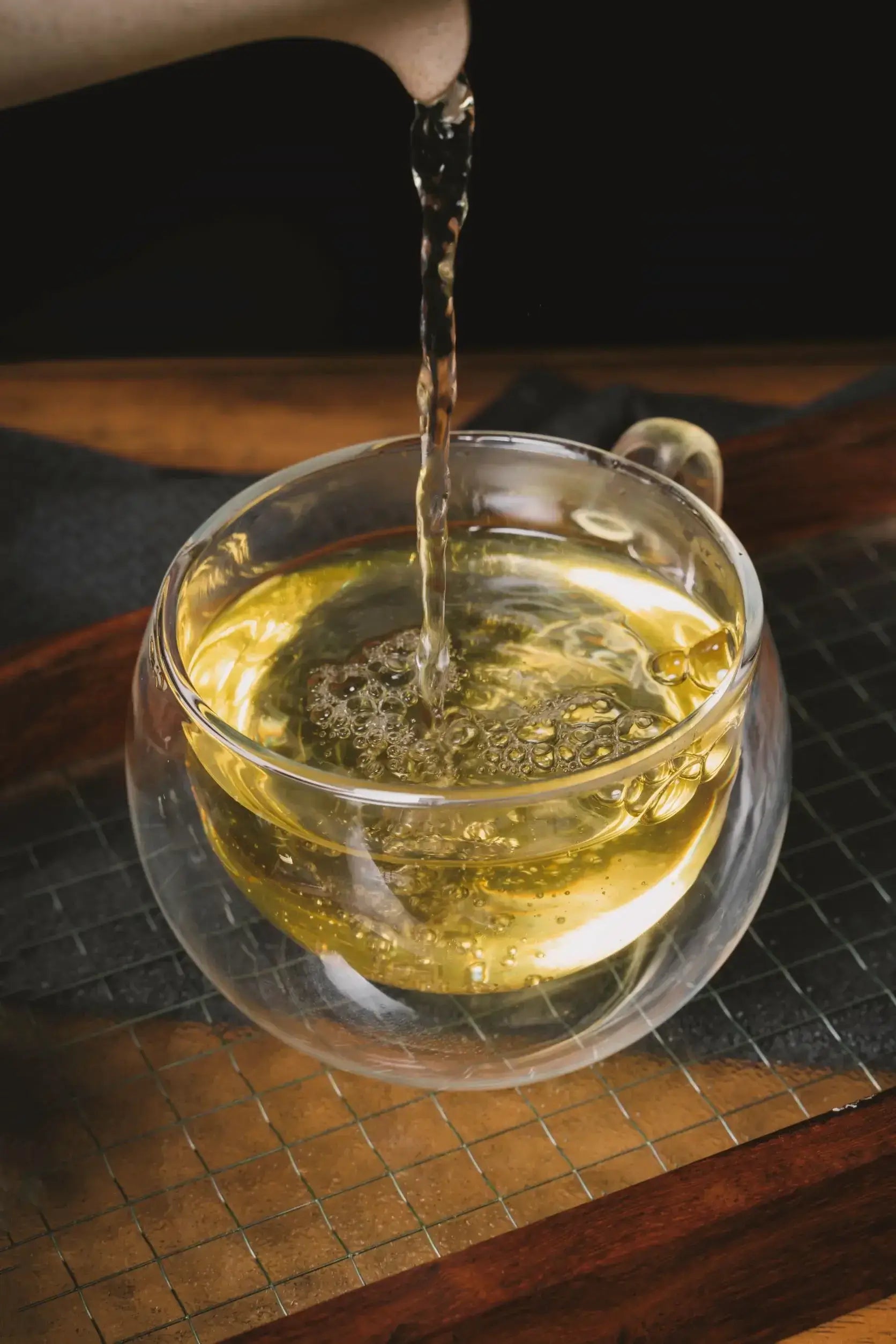 oolong tea pouring into glass teacup